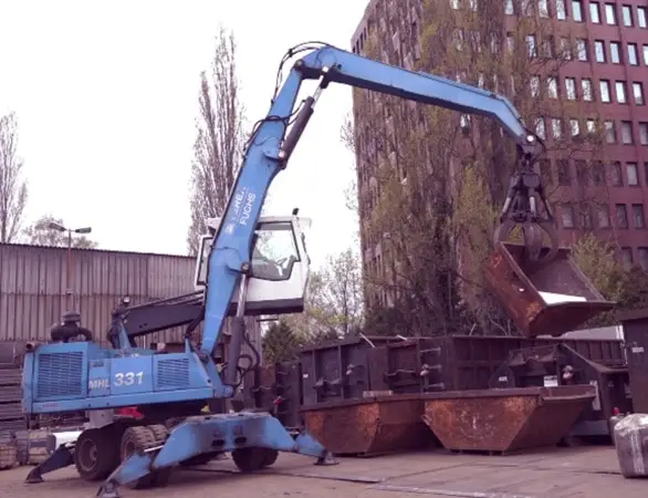 Bagger verlädt Metallschrott auf dem Schrottplatz von Peglow in Reinickendorf